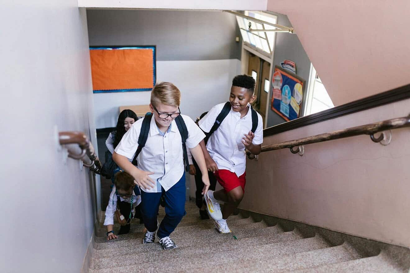 Children walking up stairs at a school. Credit: RDNE Stock project/Pexels.