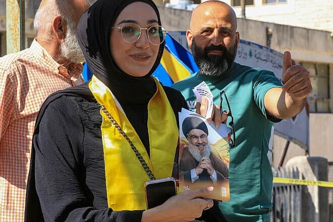 A woman holds a picture of slain Hezbollah leader Hassan Nasrallah outside a polling station during the municipal elections in Nabatieh in Southern Lebanon on May 24, 2025. Photo by Mahmoud Zayyat/AFP via Getty Images.