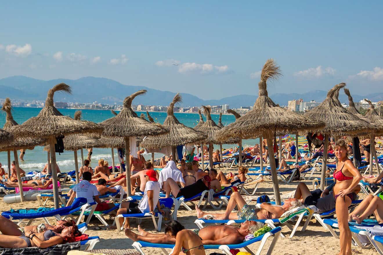 Beachgoers sunbathe in Mallorca, Spain on Oct. 2, 2016. Photo by Otto Domes