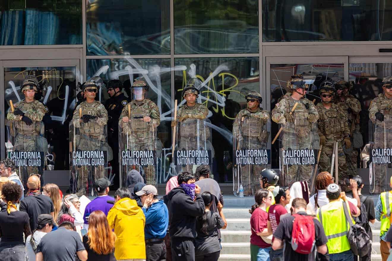California National Guard soldiers stand in front of individuals protesting against U.S. Immigration and Customs Enforcement raids of illegal immigrants in Los Angeles, June 9, 2025. Credit: U.S. Northern Command via Wikimedia Commons.