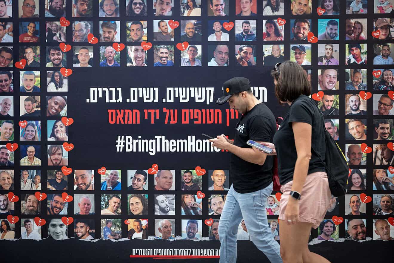 People walk past posters of Israelis who have been and are still held hostage by Hamas, in Tel Aviv. May 21, 2025. Photo by Miriam Alster/Flash90.