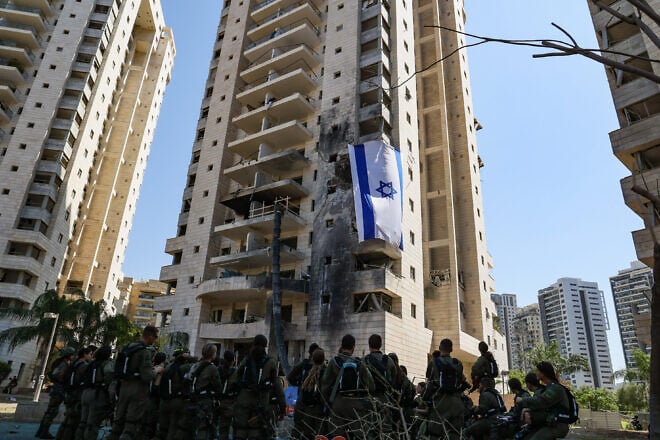 Israeli soldiers at the site where a ballistic missile fired from Iran hit and caused damage in Petach Tikvah, June 18, 2025. Photo by Jonathan Shaul/Flash90.