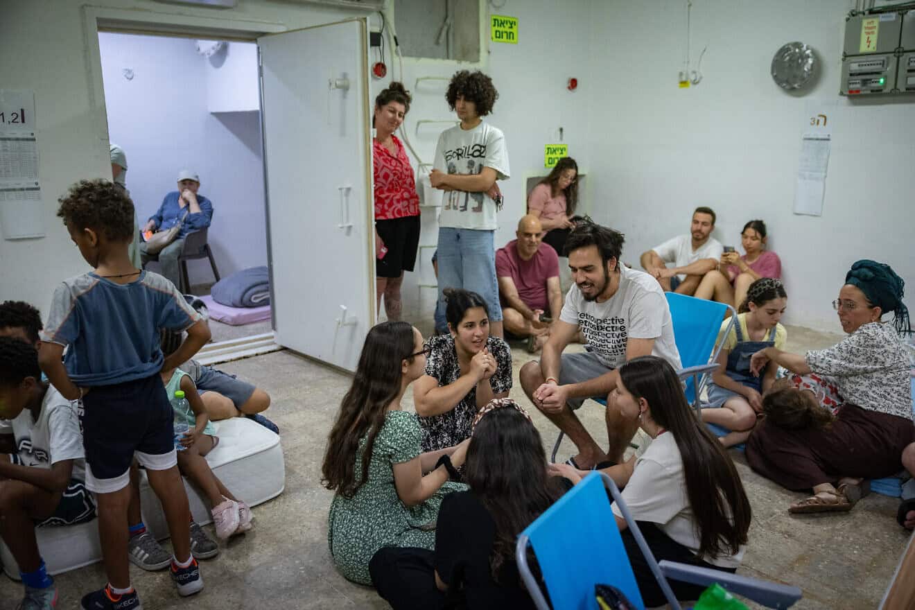 People take cover as siren warns of incoming missiles fired from Iran at a public bomb shelter in Jerusalem, June 20, 2025. Photo by Noam Revkin Fenton/Flash90.