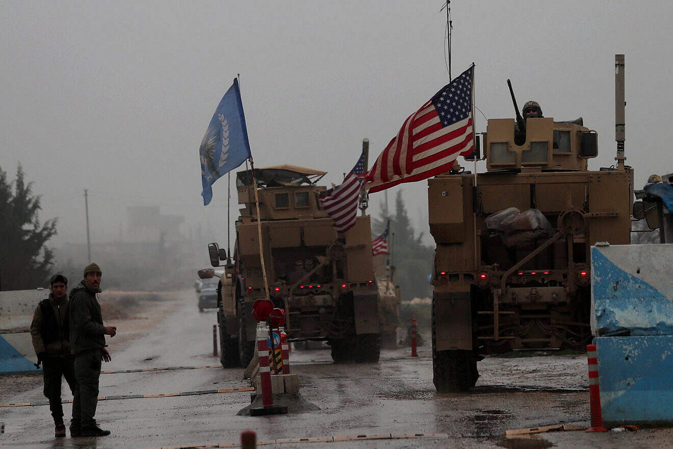 A line of U.S. military vehicles drive through a checkpoint of the Internal Security Forces in Manbij as they head to their base on the outskirts of the northern Syrian city on Dec. 30, 2018. Photo by Delil Souleiman/AFP via Getty Images.