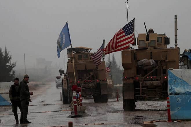 A line of U.S. military vehicles drive through a checkpoint of the Internal Security Forces in Manbij as they head to their base on the outskirts of the northern Syrian city on Dec. 30, 2018. Photo by Delil Souleiman/AFP via Getty Images.