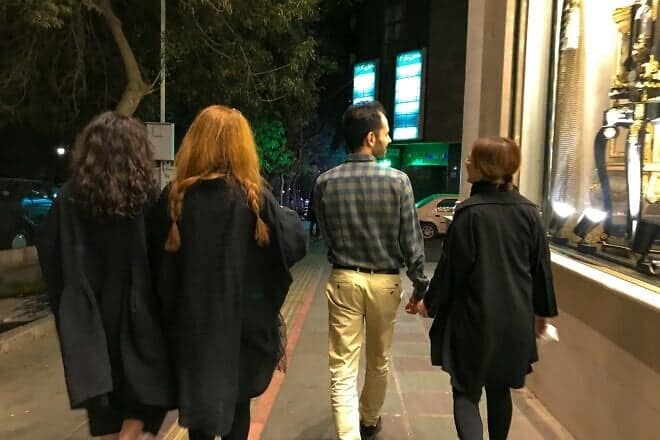 Young Iranian women walk on the streets without wearing the mandatory hijab in Tehran, on Oct. 8, 2022. Photo by Anonymous/Middle East Images/AFP via Getty Images.