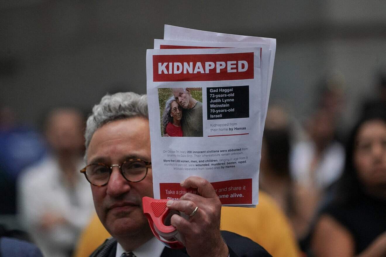A supporter of Israel holds a picture of kidnapped Israeli hostages Judith Weinstein Haggai and Gad Haggai during the "Flood Wall Street for Gaza" rally outside the New York Stock Exchange on Oct. 26, 2023. Photo by Bryan R. Smith/AFP via Getty Images.