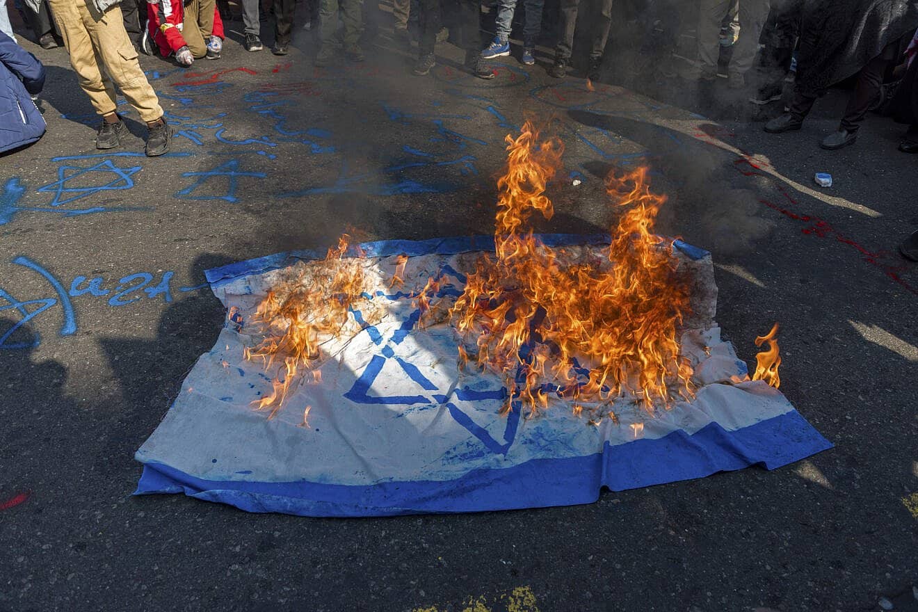Iranians burn an Israeli flag during a rally marking the 46th anniversary of the 1979 Islamic Revolution in Tehran, Feb. 10, 2025. Photo by Hossein Beris/Middle East Images/AFP via Getty Images.