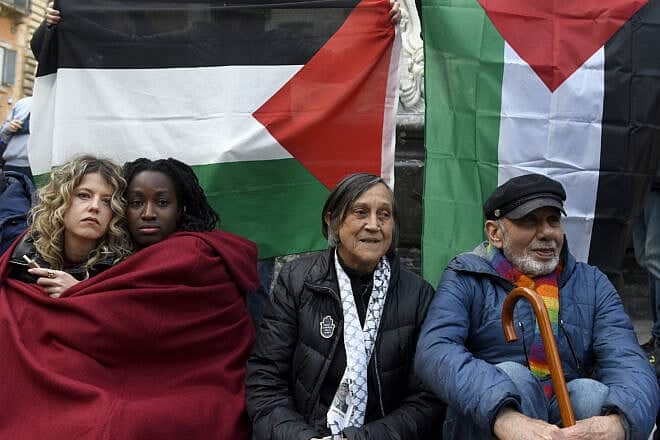 Two girls hug in front of a Palestinian flag during a demonstration in Rome's Piazza della Rotonda in solidarity with the Palestinians and against Israel's war, on March 20, 2025. Photo by Simona Granati-Corbis/Corbis via Getty Images.