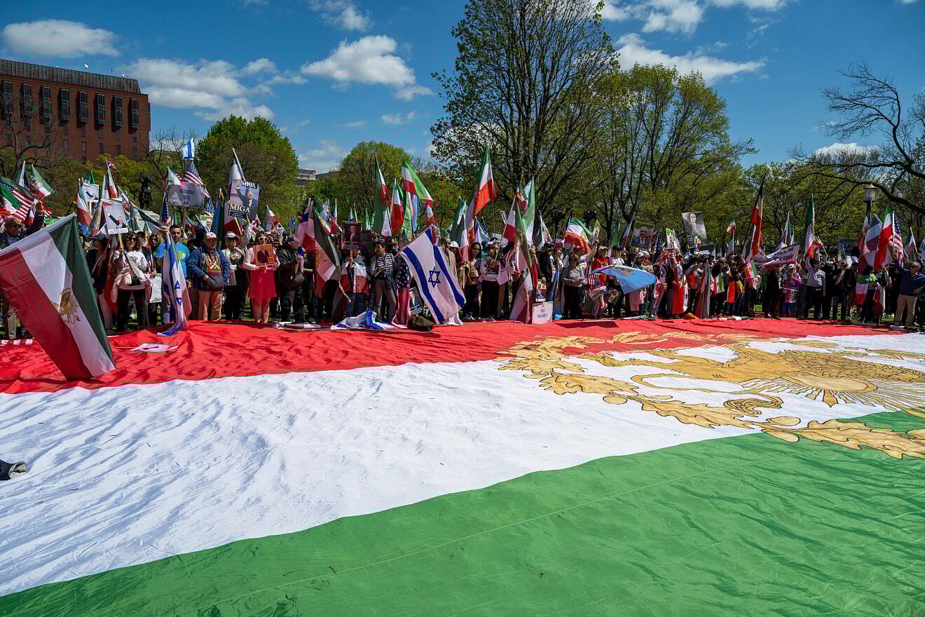 Israeli flags can be seen among ralliers outside the White House, where a large, pre-1979 Iranian flag with the Lion and Sun emblem was spread on the ground, in support of Crown Prince Reza Pahlavi, April 13, 2025. Credit: Matt Kargar/Middle East Images/AFP via Getty Images.