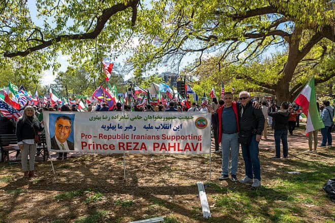 Members of the group Pro-Republic Iranians Supporting Prince Reza Pahlavi pose with a large banner in front of the White House during a rally in Washington, D.C. on April 13, 2025. The banner features a portrait of Crown Prince Reza Pahlavi and messages of support in both Persian and English. Demonstrators behind them wave pre-1979 Iranian flags, American flags, and other symbols of solidarity, calling for regime change in Iran. (Photo by Matt Kargar/Middle East Images/AFP via Getty Images)