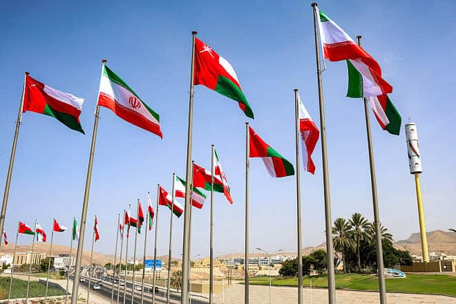 The flags of Oman and Iran fly along a highway in Muscat during the visit of the Iranian president on May 27, 2025. Photo by Haitham al-Shukairi/AFP via Getty Images.
