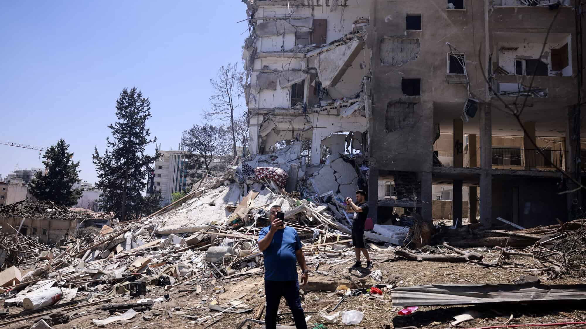 Residents snap pictures of the destruction following an Iranian missile strike in Rehovot in central Israel, on June 15, 2025. Photo by Menahem Kahana/AFP via Getty Images.