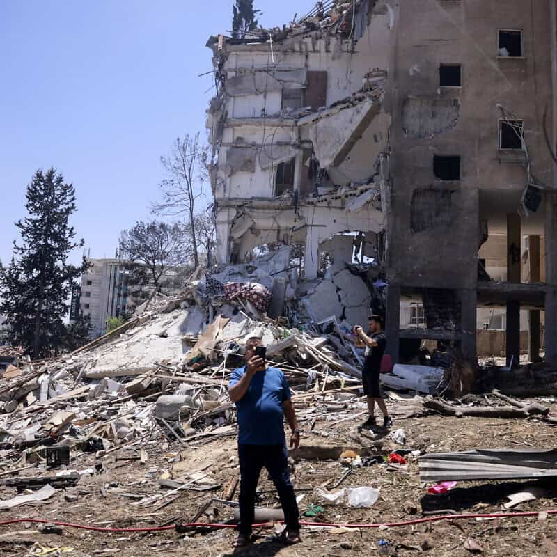 Residents snap pictures of the destruction following an Iranian missile strike in Rehovot in central Israel, on June 15, 2025. Photo by Menahem Kahana/AFP via Getty Images.