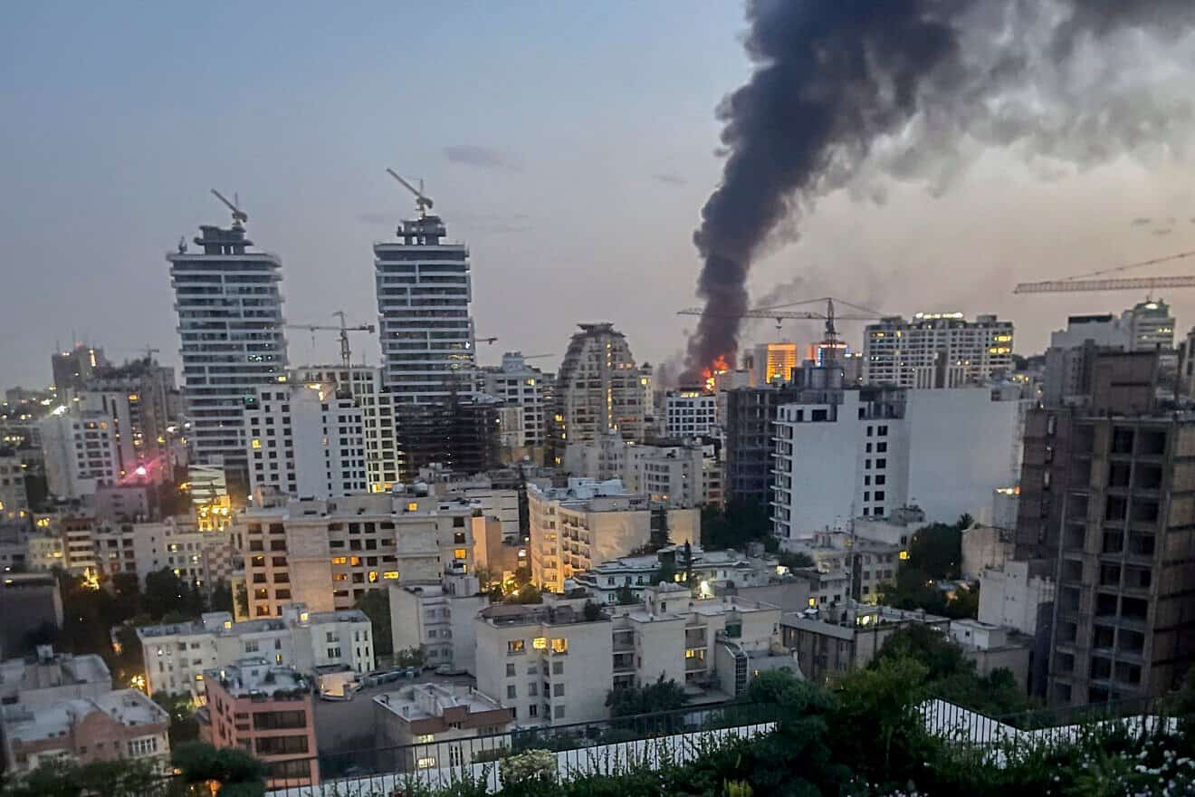 Smoke rises from the rubble of an Iranian state media building after an Israeli airstrike in Tehran, on June 16, 2025. Photo by MINA/Middle East Images/AFP via Getty Images.