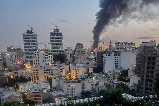 Smoke rises from the rubble of an Iranian state media building after an Israeli airstrike in Tehran, on June 16, 2025. Photo by MINA/Middle East Images/AFP via Getty Images.