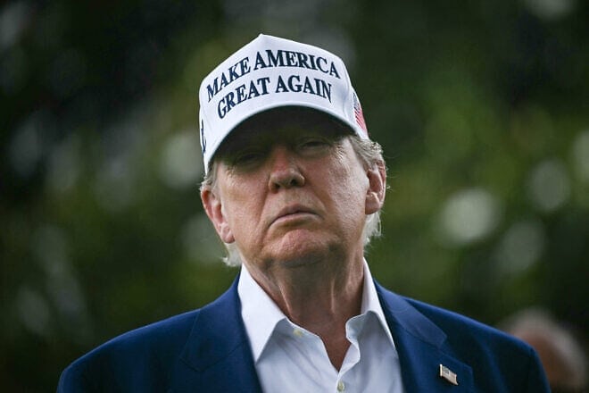 U.S. President Donald Trump speaks to the press as workers install a large flag pole on the South Lawn of the White House, June 18, 2025. Photo by Brendan Smialowski/AFP via Getty Images.