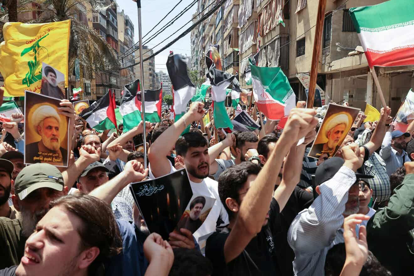 Hezbollah supporters wave PLO and Iranian flags as they demonstrate in support of Iran, after Friday noon prayers in Beirut's southern suburbs, on June 20, 2025. Photo by Anwar Amro/AFP via Getty Images.