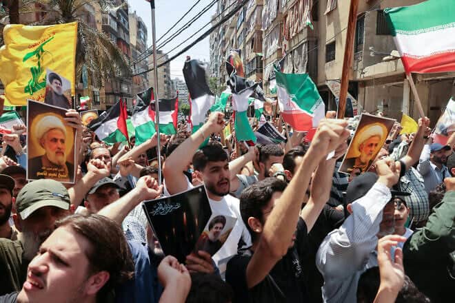 Hezbollah supporters wave PLO and Iranian flags as they demonstrate in support of Iran, after Friday noon prayers in Beirut's southern suburbs, on June 20, 2025. Photo by Anwar Amro/AFP via Getty Images.