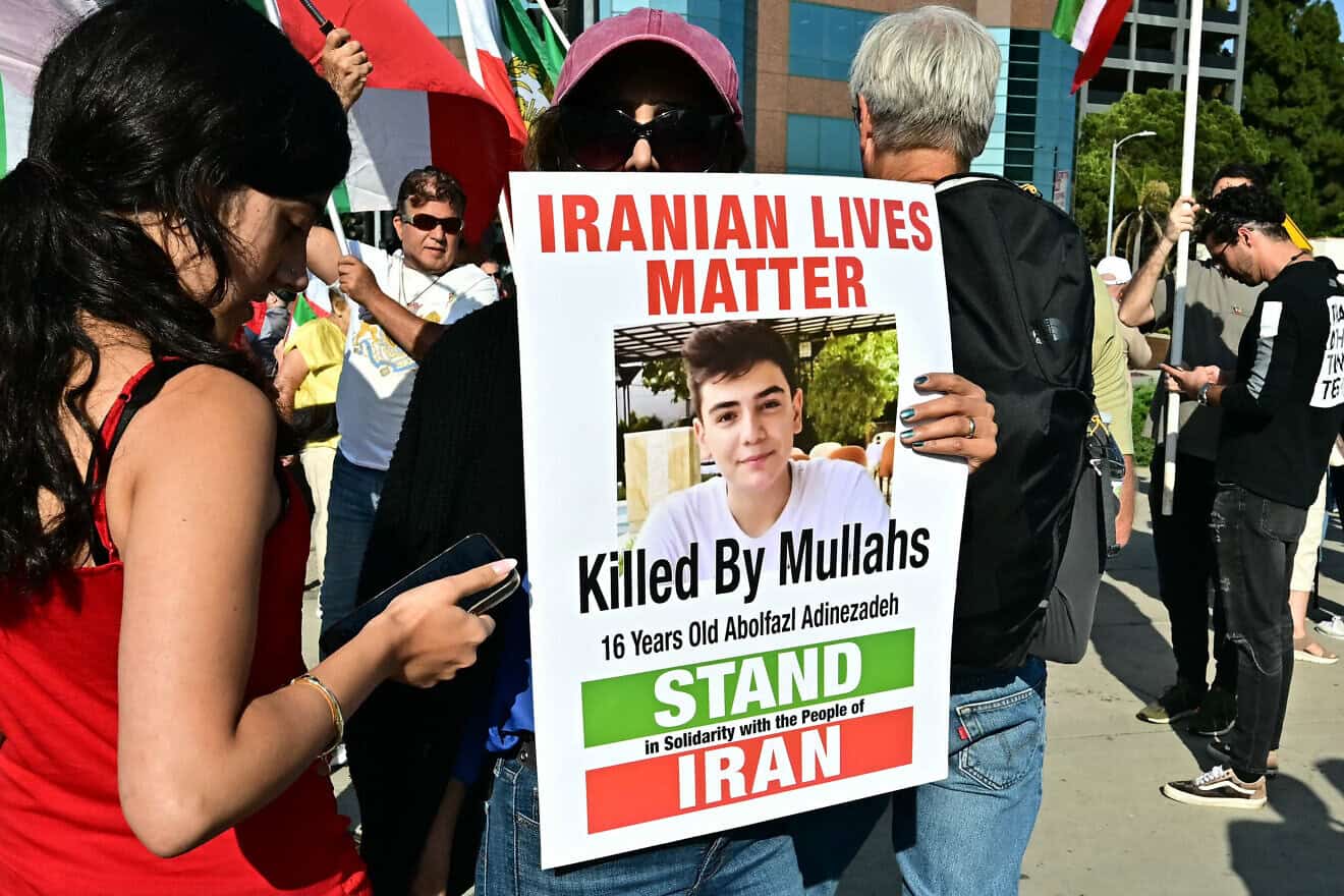 A woman holds a poster of Abolfazl Adinezadeh, a 17-year-old protester shot dead by Iranian security forces, during a rally to call for regime change in Iran, after U.S. President Donald Trump announced a ceasefire between Israel and Iran, outside the Wilshire Federal Building in Los Angeles, on June 23, 2025. Photo by Frederic J. Brown/AFP via Getty Images.