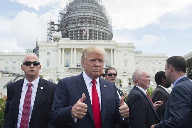 U.S. Republican Presidential hopeful Donald Trump gives a thumbs-up as he arrives for a Tea Party rally against the international nuclear agreement with Iran outside the U.S. Capitol in Washington, DC, Sept. 9, 2015. Photo by Saul Loeb/AFP via Getty images.