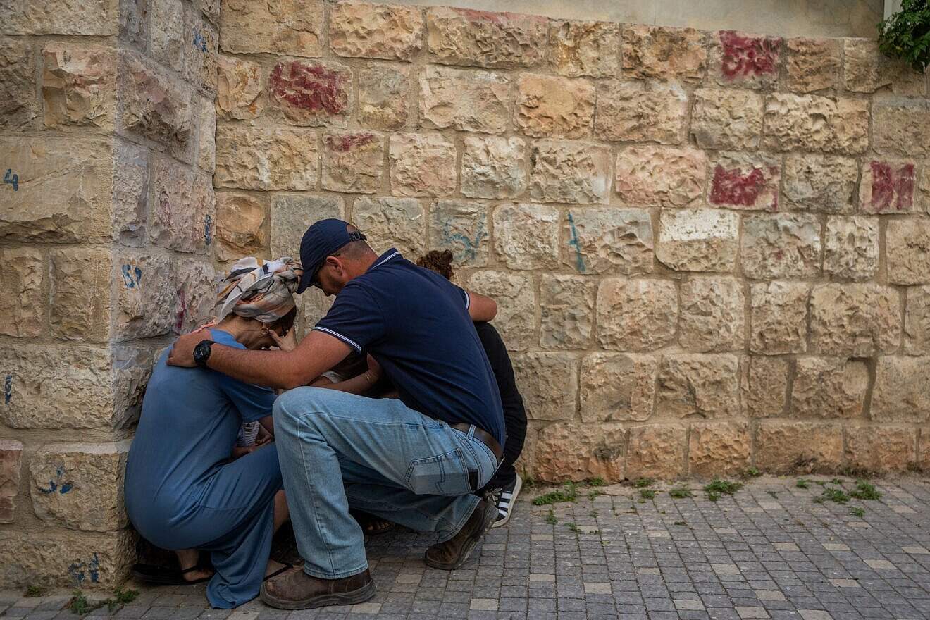 A family takes cover in Jerusalem as sirens warns of a missile fired by Houthi terrorists in Yemen, June 1, 2025. Photo by Chaim Goldberg/Flash90.