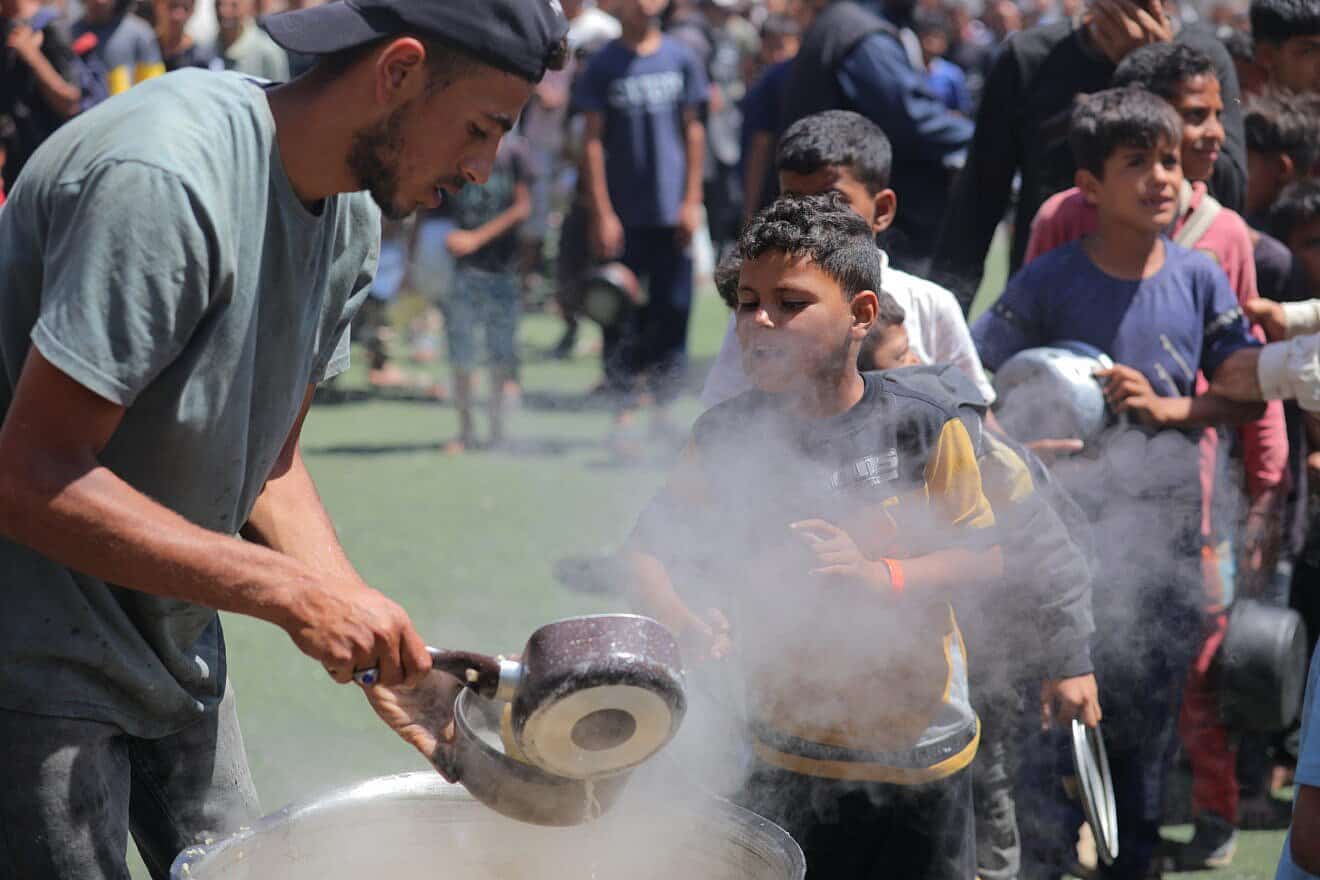 Palestinian children receive meals from volunteers in Gaza City, on May 29, 2025. Photo by Ali Hassan/Flash90.