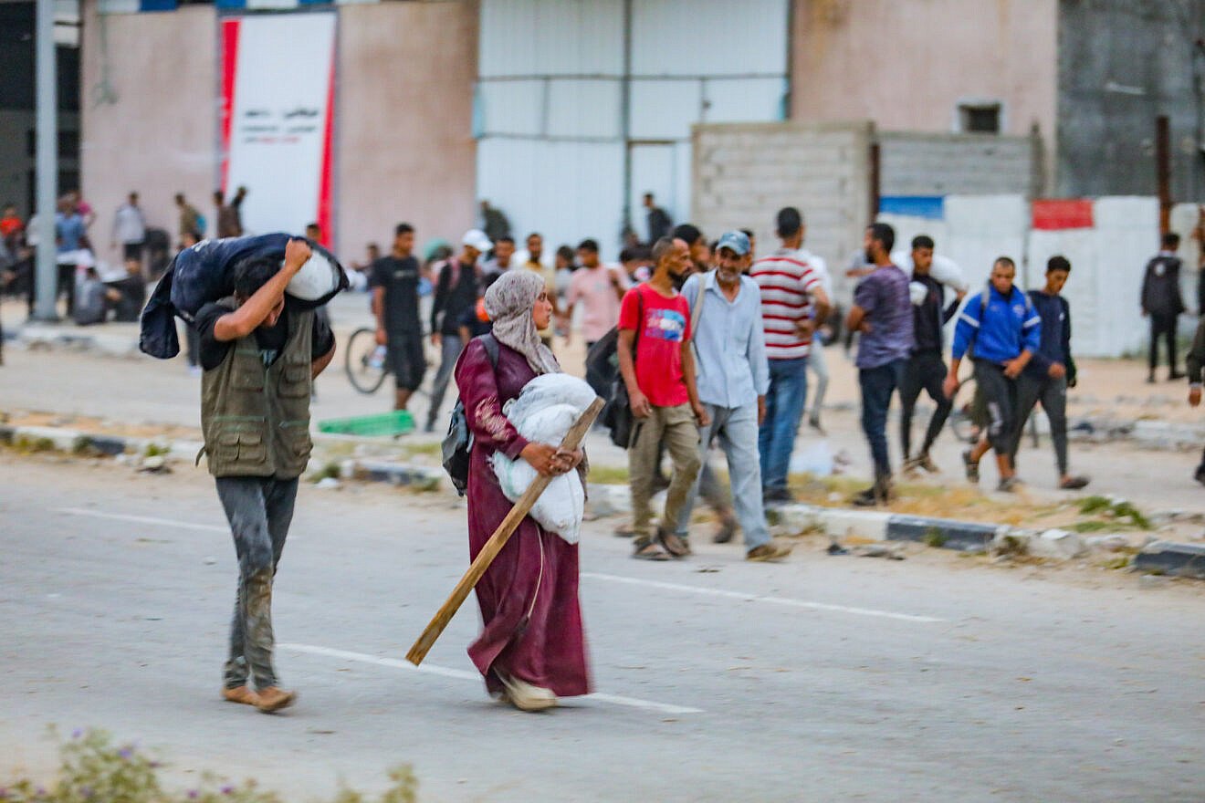 Palestinians walking near an aid-distribution point in the Netzarim Corridor in the central Gaza Strip, June 9, 2025. Photo by Ali Hassan/Flash90.