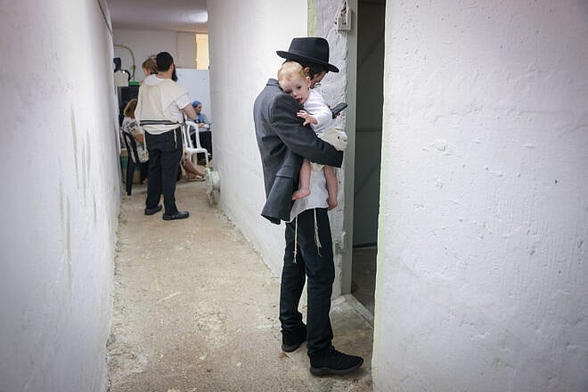 Orthodox Jews study Torah in a public shelter in northern Israel during alarms and rocket and missile fire from Iran, June 15, 2025. Photo by David Cohen/Flash90.