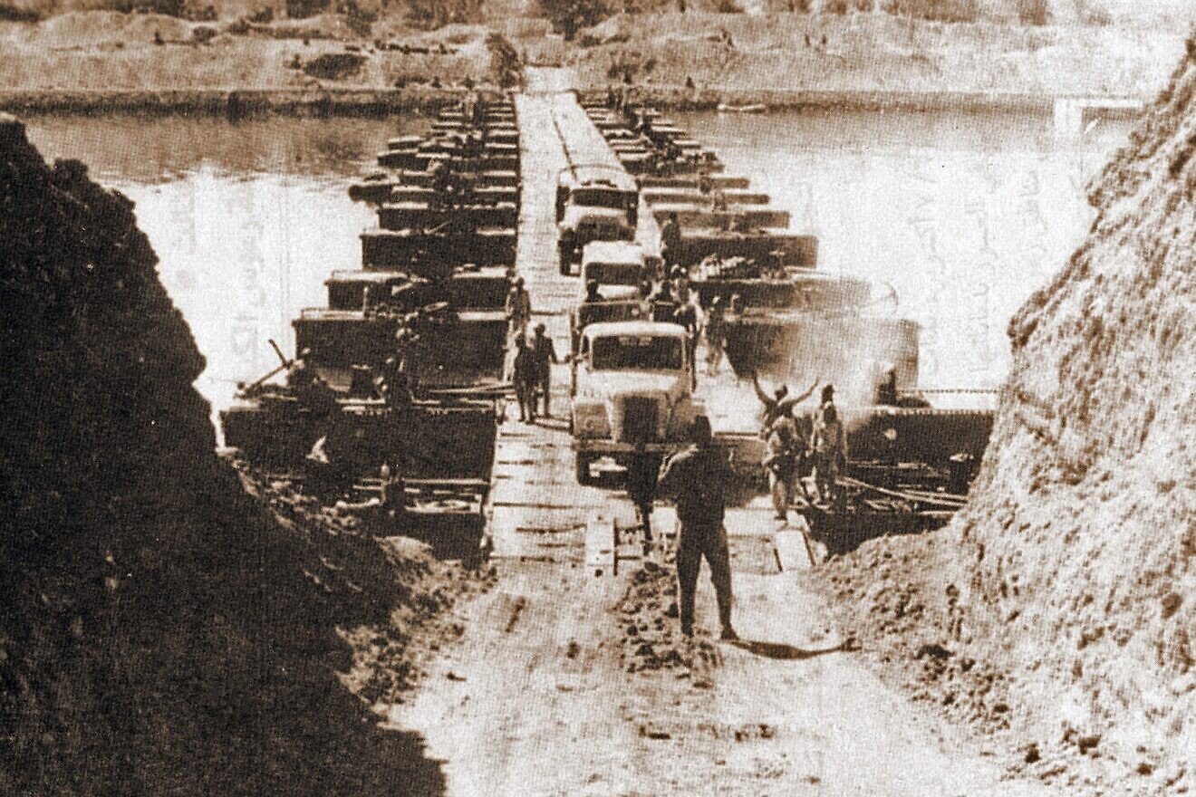 Egyptian military trucks cross a bridge laid over the Suez Canal during the Yom Kippur War, Oct. 7, 1973. Credit: U.S. Government/Public Domain via Wikimedia Commons.