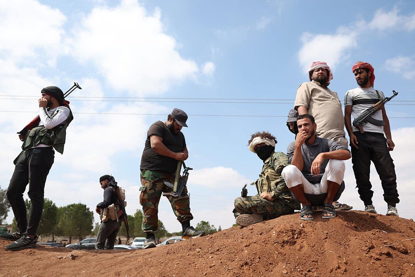 Bedouin tribal gunmen stand next to a government checkpoint in Busra al-Hariri, Syria, set up to prevent them from advancing toward Sweida city, on July 20, 2025. Photo by Omar Haj Kadour/AFP via Getty Images.