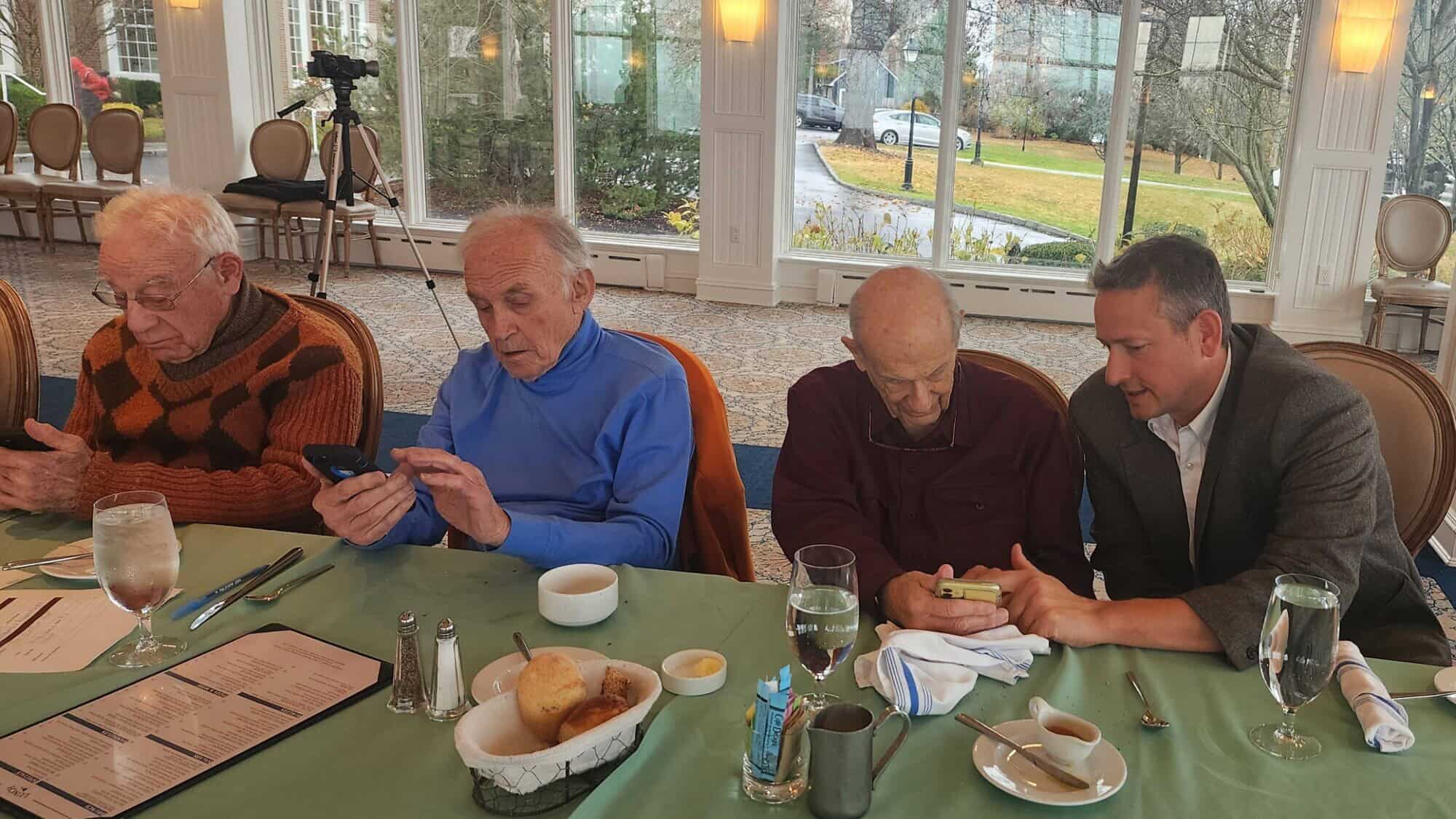 Dan Rosen (right), co-founder and co-chair of the new Emissary app, teaches Jewish community members how to use it. Credit: Courtesy.