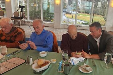Dan Rosen (right), co-founder and co-chair of the new Emissary app, teaches Jewish community members how to use it. Credit: Courtesy.
