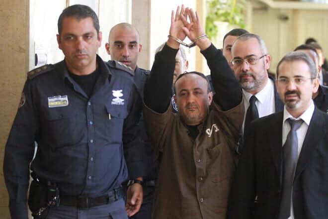 Marwan Barghouti (center), who is serving a life sentence for his role in the Second Intifada, is escorted by Israeli police into Jerusalem's Magistrate Court to testify as part of a U.S. civil lawsuit against the Palestinian leadership on Jan. 25, 2012. Credit: Flash90.