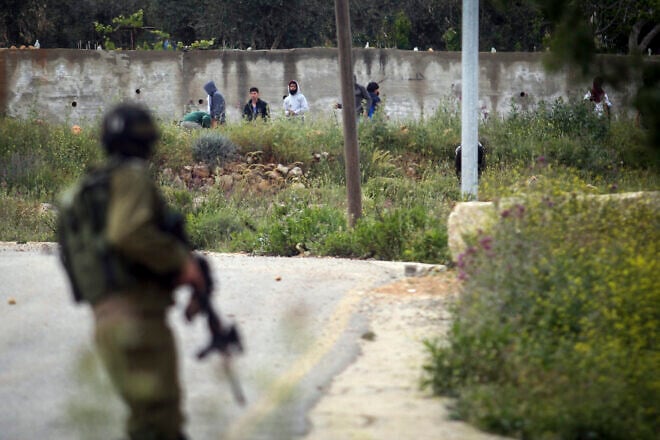 Palestinian terrorists throw rocks towards Israeli security forces in the Samaria village of Sinjil, April 13, 2015. Photo by STR/Flash90.