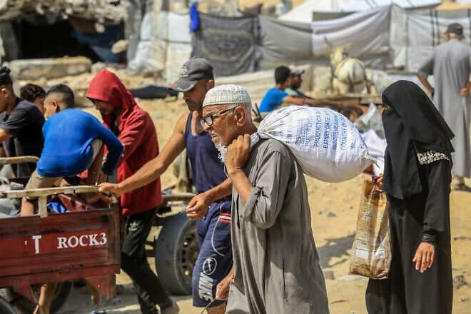 Palestinians carry food supplies they received from the U.S. aid center in Rafah, in the southern Gaza Strip, on July 30, 2025. Photo by Abed Rahim Khatib/Flash90.