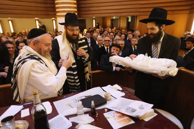 Orthodox Jews pass around a newborn before his circumcision at the Chabad Lubawitsch Orthodox Jewish synagogue in Berlin, Germany, March 3, 2013. Photo by Sean Gallup/Getty Images.