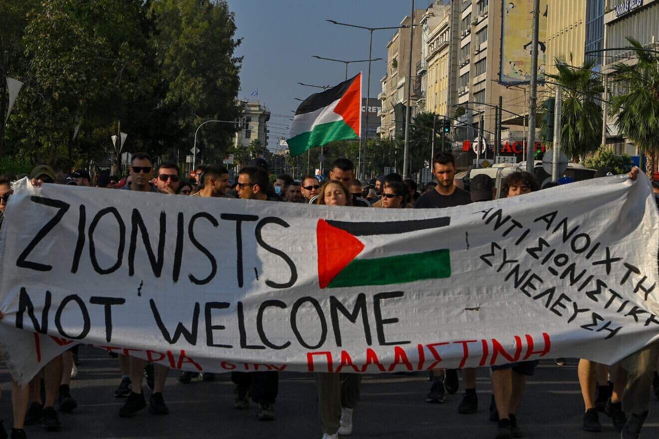 Pro-Palestinian demonstrators carry a banner during a protest against the arrival of an Israeli cruise ship in the port of Piraeus on June 12, 2025 in Athens, Greece. Photo by Milos Bicanski/Getty Images.