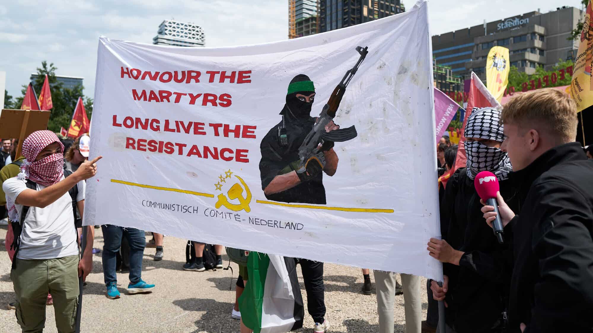 Anti-NATO protesters and members of the Communist Comity of The Netherlands hold a banner in support of Hamas fighters on June 22, 2025 in The Hague, Netherlands. Photo by Pierre Crom/Getty Images.