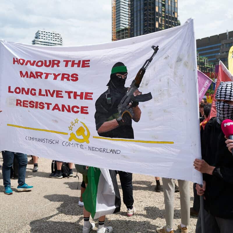 Anti-NATO protesters and members of the Communist Comity of The Netherlands hold a banner in support of Hamas fighters on June 22, 2025 in The Hague, Netherlands. Photo by Pierre Crom/Getty Images.