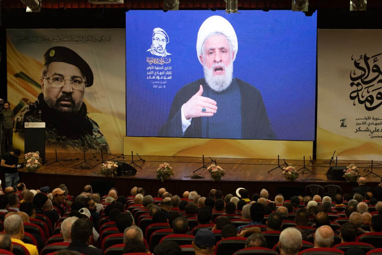 Hezbollah leader Naim Qassem, delivers a televised speech at a ceremony in Hadath, near Beirut, commemorating the first anniversary of the death of Fuad Shukr, pictured beside Qassem, on July 30, 2025. Photo by Daniel Carde/Getty Images.