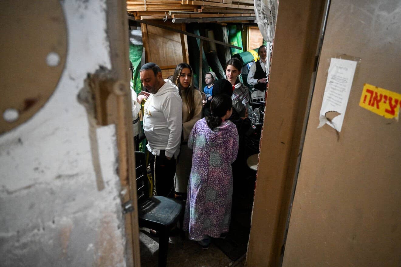 People take cover in a stairway in Jerusalem, as a Red Alert is sounded, when drones and missiles fired from Iran into Israel, April 14, 2024. Photo by Arie Leib Abrams/Flash90.