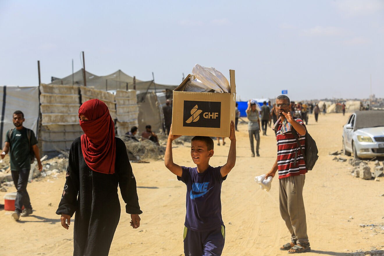 Gazans carry food they received from the U.S. aid center in Rafah, the southern Strip, on July 30, 2025. Photo by Abed Rahim Khatib/Flash90.