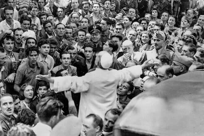People gather around Pope Pius XII during a visit to the Lateran in Rome after an American air raid on Aug. 13, 1943. Credit: AP Photo file via Wikimedia Commons.