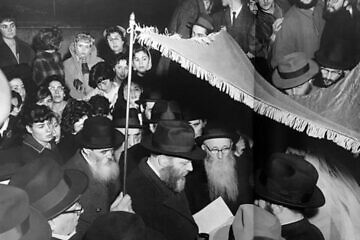 Rabbi Avraham Korf and Rivka Eichenbaum married in 1960 in Brooklyn, N.Y., officiated by the Lubavitcher Rebbe, Rabbi Menachem Mendel  Schneerson (center). Credit: Kehot Publication Society.
