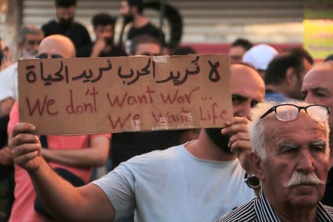 A Syrian carries a placard during protest of the humanitarian situation in the predominantly Druze city of Sweida on July 28, 2025. A new humanitarian aid convoy reached southern Syria's Druze heartland on July 28, official media said, as the United Nations warned the humanitarian situation in Sweida province was critical after deadly violence. Photo by Shadi Al-Dubaisi/AFP via Getty Images.