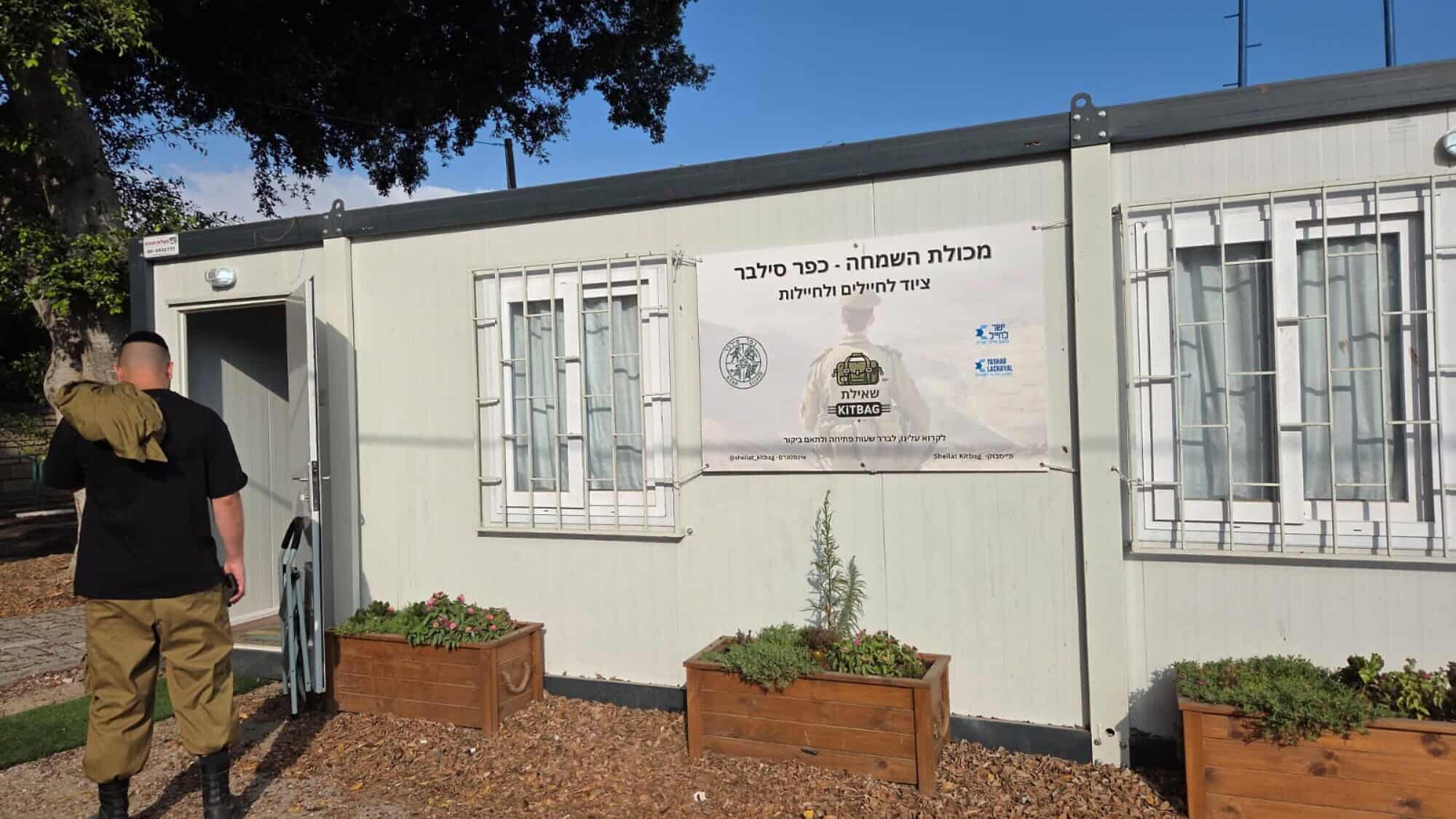 A soldier carrying a kitbag enters the new center of She'ilat KITBAG in Hof Ashkelon on Sunday morning, July 13, 2025. Credit: Courtesy.