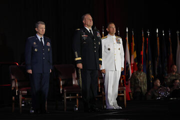 U.S. Army Gen. Michael Erik Kurilla (center), the outgoing commander of U.S. Central Command (CENTCOM), with U.S. Air Force Gen. Dan Caine (left), chairman of the Joint Chiefs of Staff, and U.S. Navy Adm. Brad Cooper (right), the incoming commander of CENTCOM, stand at attention at a change of command ceremony in Tampa, Fla., on Aug. 8, 2025. Credit: Tom Gagnier/U.S. Central Command Public Affairs.