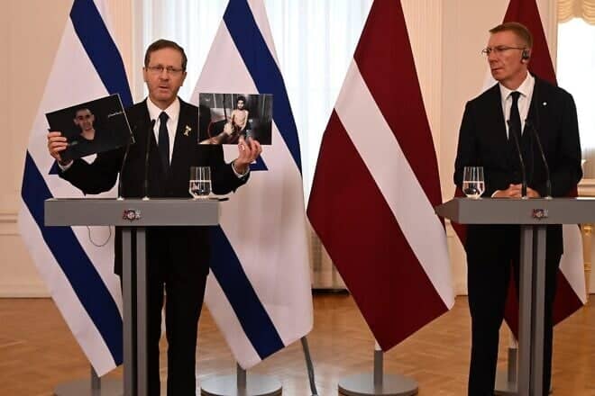 Israeli President Isaac Herzog holds up images of Israeli hostages Evyatar David and Rom Braslavski as Latvian President Edgars Rinkēvičs looks on during their joint press conference in Riga, Latvia, on Aug. 5, 2025. Photo: Haim Zach/GPO.