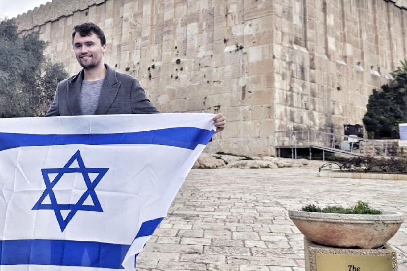 Charlie Kirk holds an Israeli flag outside the Cave of the Patriarchs in Hebron during his visit in 2019. Credit: Itamar Ben-Gvir/X.